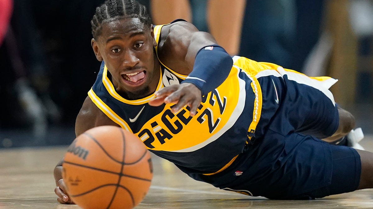 Indiana Pacers' Caris LeVert dives for a looser ball during the first half of an NBA basketball game against the Detroit Pistons, Thursday, Dec. 16, 2021, in Indianapolis.