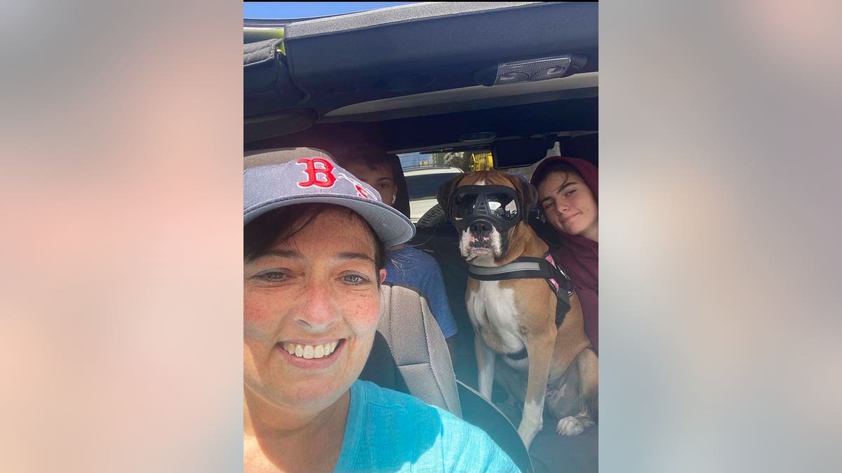 This 2021 photo provided by Cheri Burness shows Burness and her family, including dog Lilikoi, in a car in Honolulu. 
