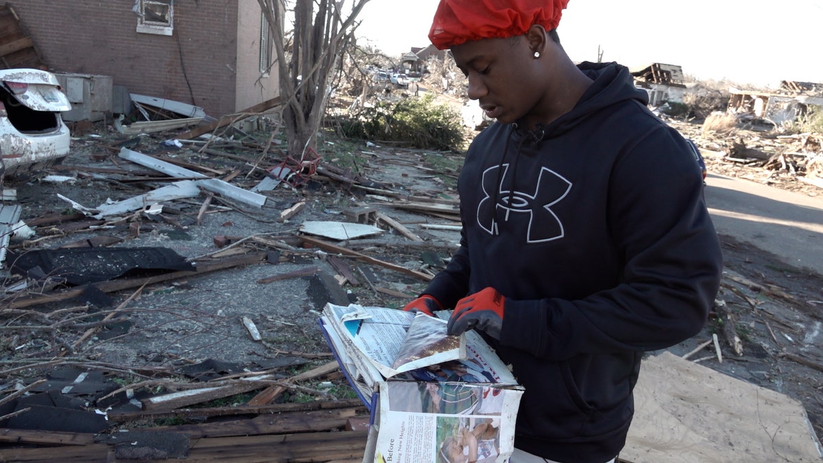 Ja-sean Kocatow finds a yearbook in the rubble of his Mayfield, Kentucky backyard