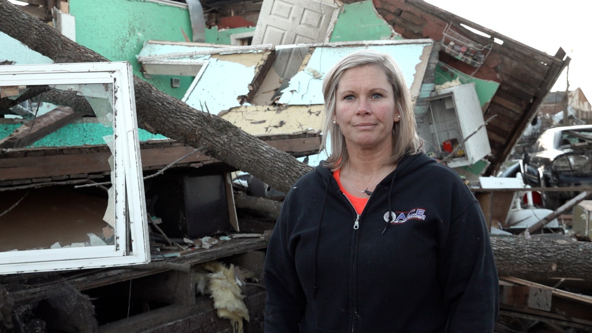 Danielle Kemp stands in front of tornado aftermath