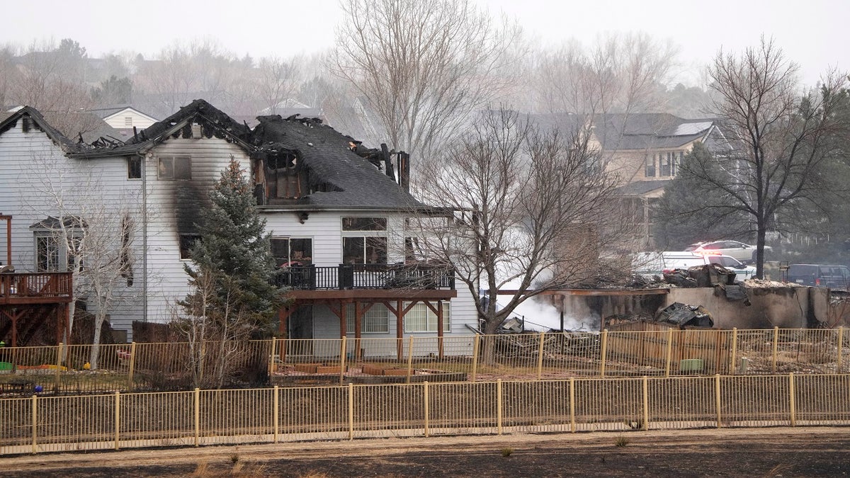 The remains of homes smolder Friday after wildfires ripped through a development in Superior, Colo.