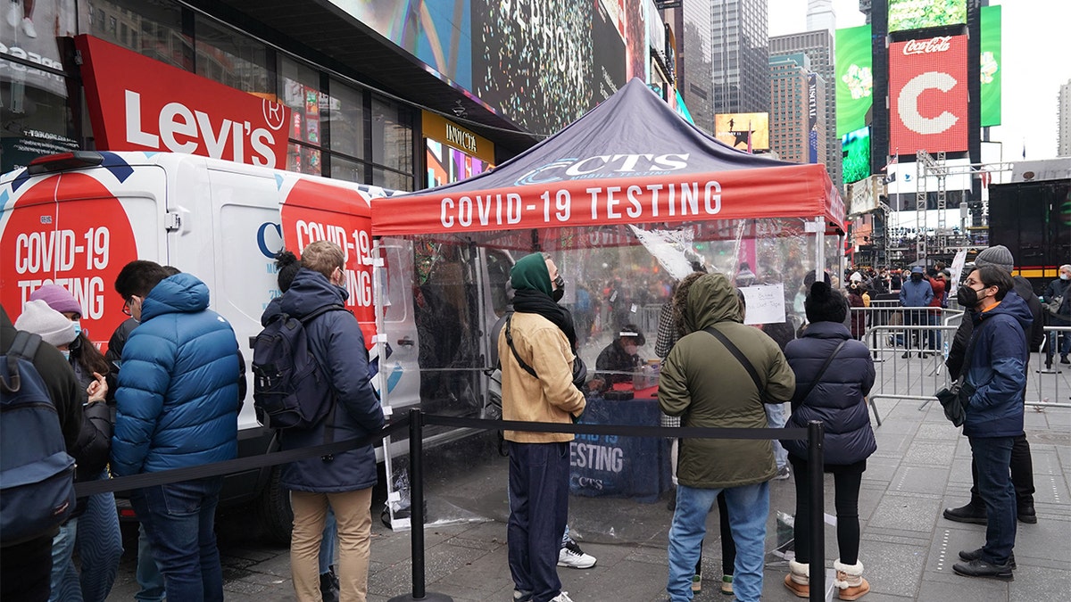People stand in line for a Covid-19 test at a mobile testing site in Times Square on December 28, 2021 in New York. (Photo by Bryan R. Smith / AFP) (Photo by BRYAN R. SMITH/AFP via Getty Images)