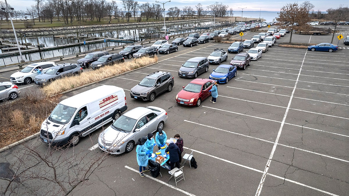 STAMFORD, CONNECTICUT - DECEMBER 28: In an aerial view, health workers administer Covid-19 PCR tests at an outdoor testing site aside the Long Island Sound on December 28, 2021 in Stamford, Connecticut. Following holiday gatherings, people scrambled to get tested, as the Omicron variant spread through the U.S. (Photo by John Moore/Getty Images)
