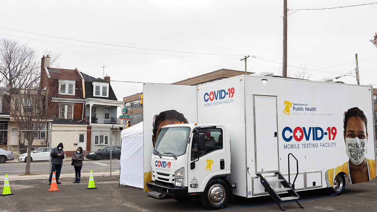 Residents wait in line to receive a Covid-19 test at a Philadelphia Department of Public Health mobile testing site in Philadelphia on Wednesday, Dec. 8, 2021.?Photographer: Hannah Beier/Bloomberg via Getty Images