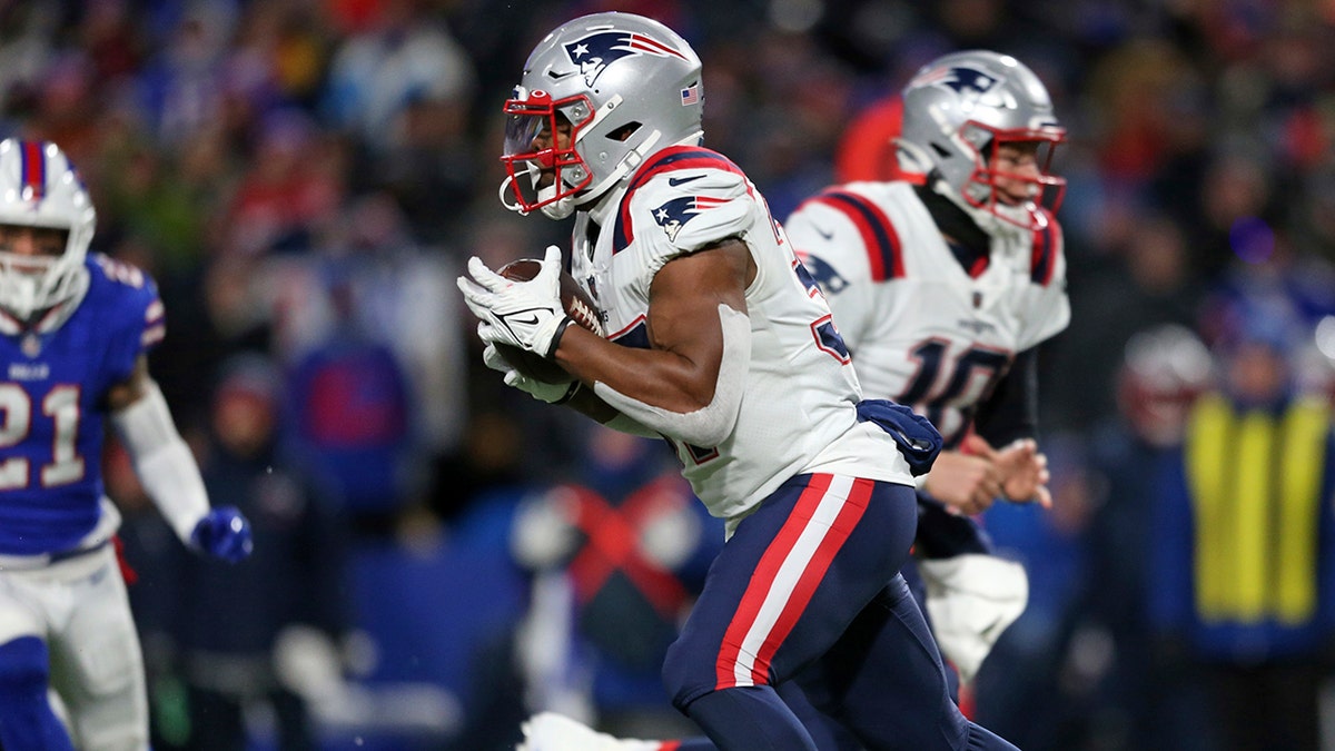 New England Patriots running back Damien Harris, center, takes a hand off from New England Patriots quarterback Mac Jones (10) for a touchdown during the first half of an NFL football game against the Buffalo Bills in Orchard Park, N.Y., Monday, Dec. 6, 2021. ()