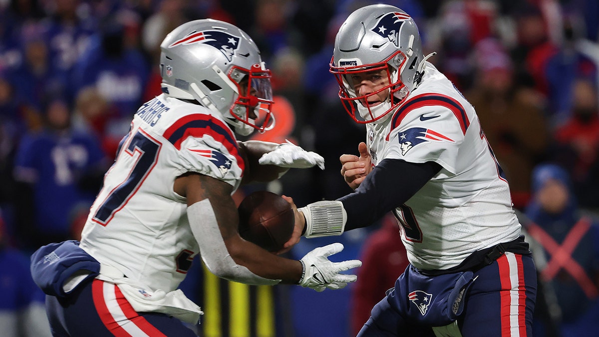 Mac Jones of the New England Patriots hands the ball off to Damien Harris (37) of the New England Patriots during the first quarter against the Buffalo Bills at Highmark Stadium on Dec. 6, 2021, in Orchard Park, New York. 