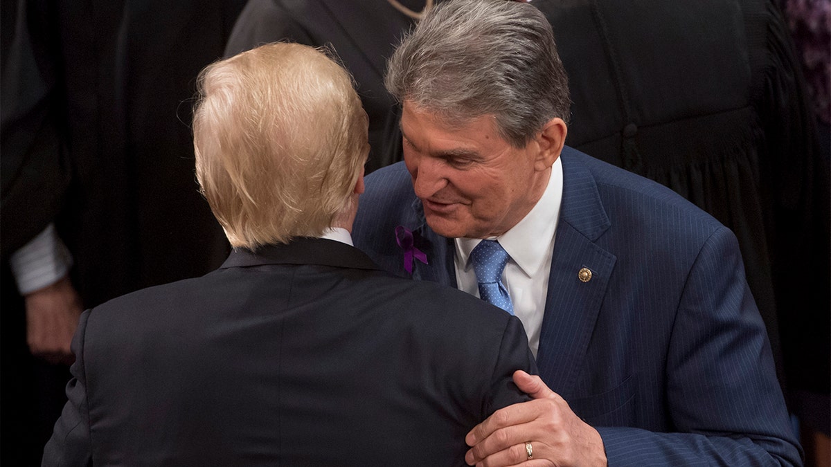 President Trump embraces Sen. Joe Manchin, Democrat of West Virginia, after speaking during the State of the Union Address before a Joint Session of Congress at the U.S. Capitol in Washington, Jan. 30, 2018. 