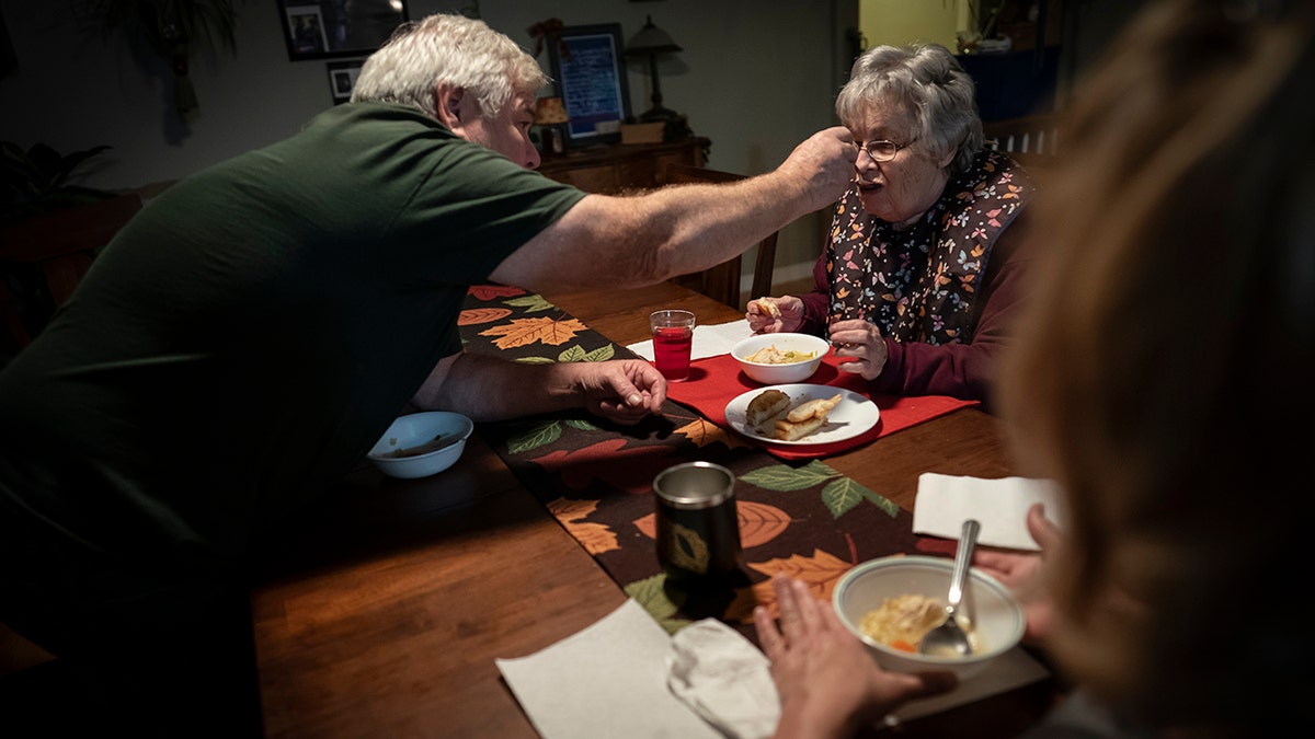 Jimmy Ryder feeds his mother-in-law, Betty Bednarowski, during dinner, Monday, Nov. 29, 2021, in Rotterdam Junction, New York.