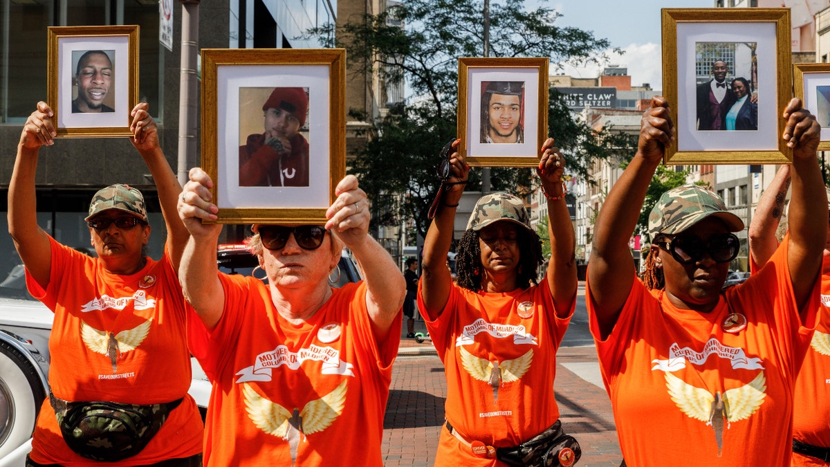 COLUMBUS, OHIO, UNITED STATES - 2021/08/01: Mothers of Murdered Columbus Children stand at the intersection of High Street and Broad Street while holding pictures of their deceased children. In reaction to the rising violence since 2020 Malissa Thomas-St. Clair, a mother of a murdered son, Anthony Thomas-St. Clair, founded Mothers of Murdered Columbus Children (MOMCC), an anti-violence group seeking to end violent crime in Columbus, Ohio. MOMCC led the effort for a Central Ohio Anti-Violence March &amp; Rally at City Hall featuring many other mothers who lost children to violence, the Ceasefire initiative led by Al Edmondson and many other community and governmental leaders. The rally and March started off with many speakers, concluding a march around downtown, and a benediction by Pastor Michael Young. (Photo by Stephen Zenner/SOPA Images/LightRocket via Getty Images)