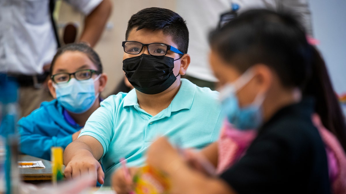 Elementary students in classroom wear masks in Los Angeles, California