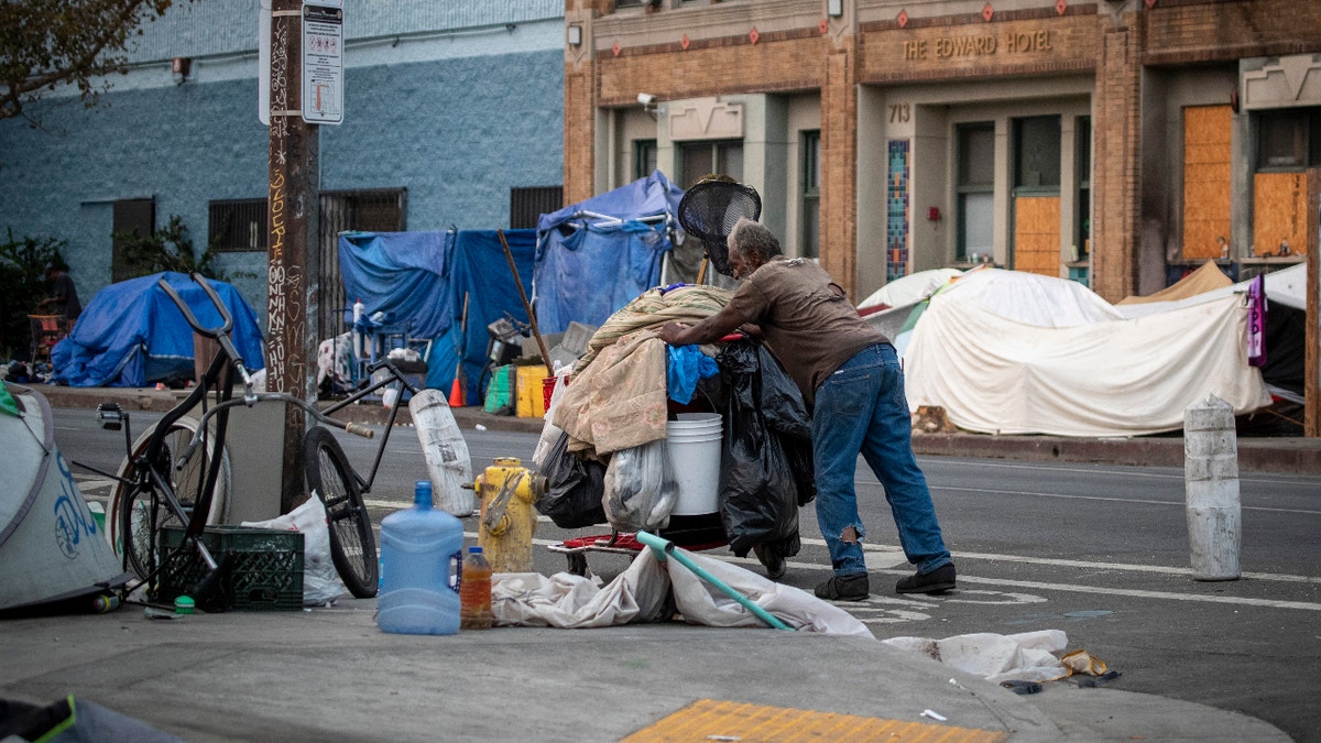  A person pushes a cart of their belongings through a homeless encampment on Skid Row Thursday, Sept. 23, 2021 in Los Angeles, CA. A federal appeals court on Thursday unanimously overturned a a judge's decision that would have required Los Angeles to offer some form of shelter or housing to the entire homeless population of skid row by October. (Allen J. Schaben / Los Angeles Times via Getty Images)
