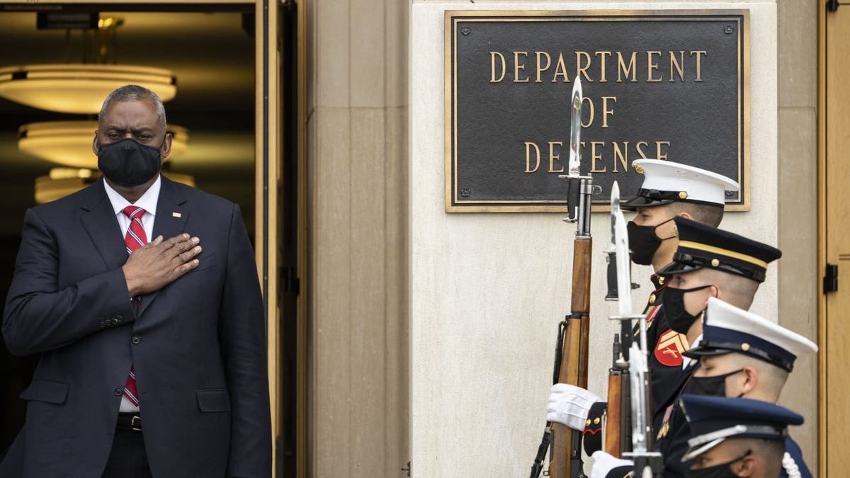 Secretary of Defense Lloyd Austin stands for the national anthem. 