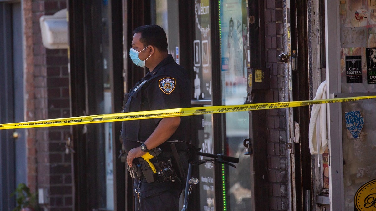 An NYPD officer monitors a crime scene in New York City.