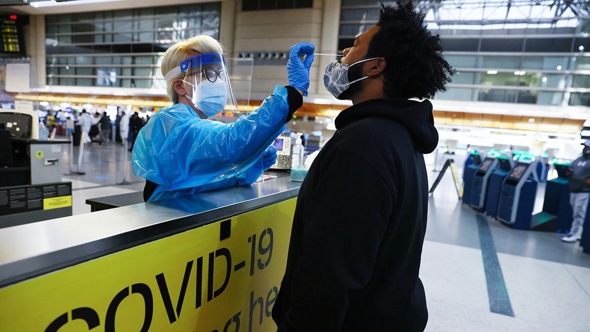 A man receives a nasal swab COVID-19 test at Tom Bradley International Terminal at Los Angeles International Airport