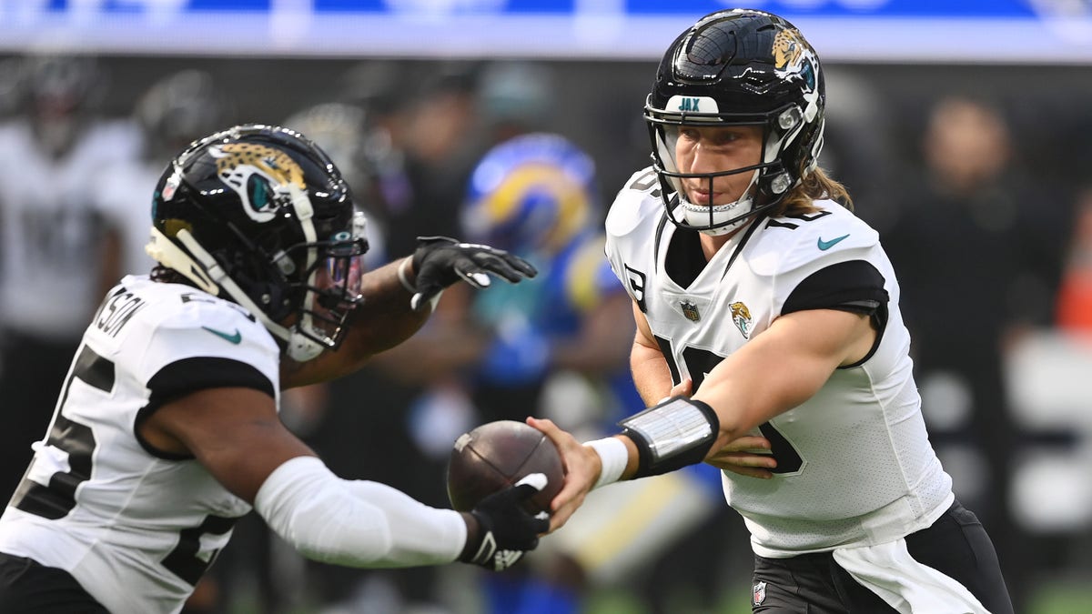 INGLEWOOD, CALIFORNIA - DECEMBER 05: Trevor Lawrence #16 of the Jacksonville Jaguars hands the ball off to James Robinson #25 of the Jacksonville Jaguars during the first quarter against the Los Angeles Rams at SoFi Stadium on December 05, 2021 in Inglewood, California. 