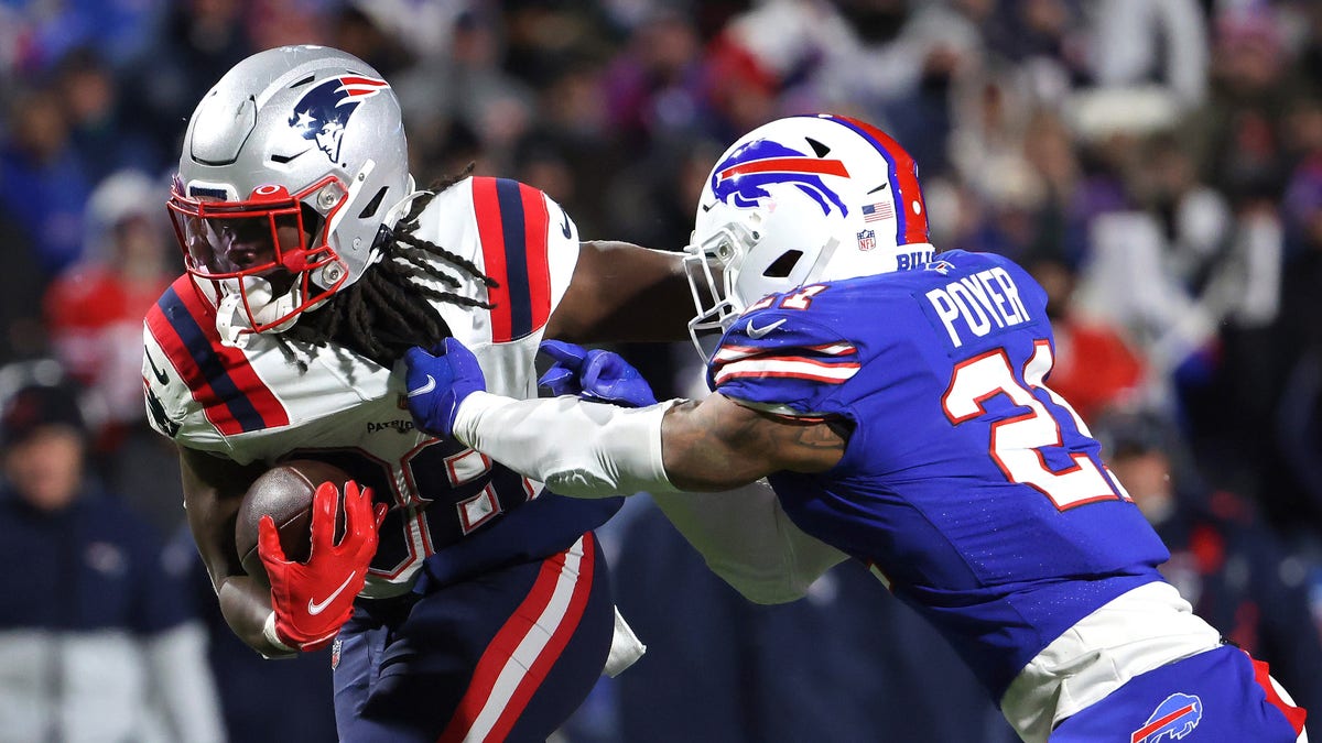 Rhamondre Stevenson (38) of the New England Patriots carries the ball as Jordan Poyer (21) of the Buffalo Bills tackles in the third quarter of the game at Highmark Stadium on Dec. 6, 2021, in Orchard Park, New York. 