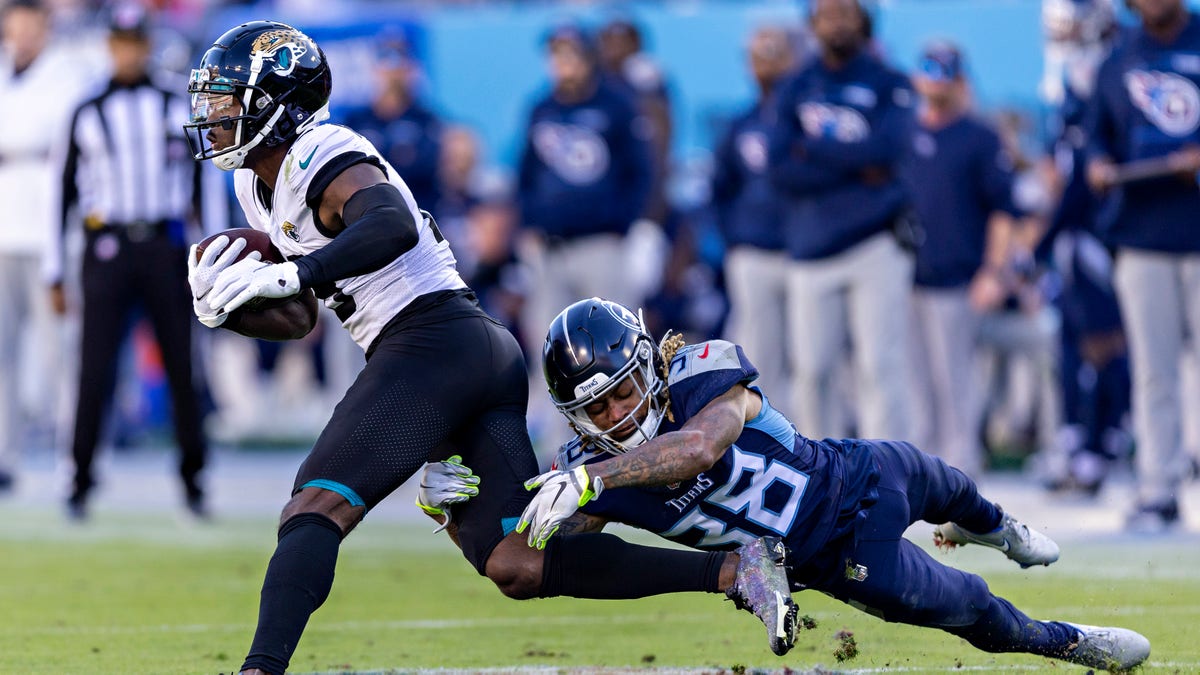 Buster Skrine #38 of the Tennessee Titans tackles James Robinson #25 of the Jacksonville Jaguars at Nissan Stadium on December 12, 2021 in Nashville, Tennessee. ?The Titans defeated the Jaguars 20-0.?