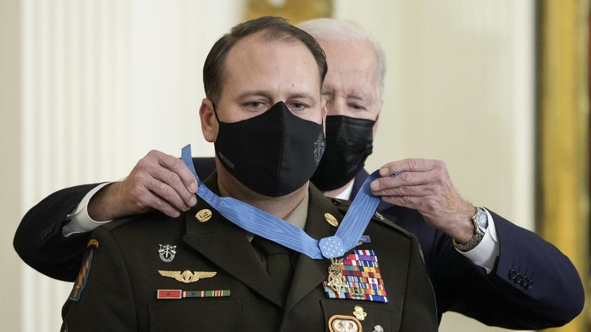 WASHINGTON, DC - DECEMBER 16: U.S. President Joe Biden awards the Medal of Honor to Army Master Sgt. Earl Plumlee in the East Room of the White House December 16, 2021 in Washington, DC. Plumlee, an Army Green Beret, is receiving the medal for his efforts to repel a suicide attack by Taliban fighters at Forward Operating Base Ghazni in Afghanistan in August 2013. 