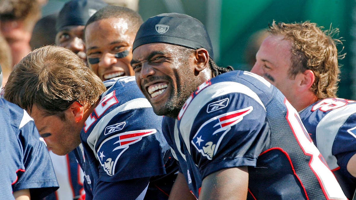 There were smiles all around on the Patriots bench after quarterback Tom Brady, left, and wide receiver Randy Moss, front, hooked up for a third quarter 51-yard touchdown pass. 