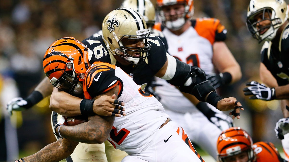Glenn Foster (97) of the New Orleans Saints tackles Jeremy Hill (32) of the Cincinnati Bengals during the second half against the New Orleans Saints at Mercedes-Benz Superdome on Nov. 16, 2014, in New Orleans, Louisiana. 