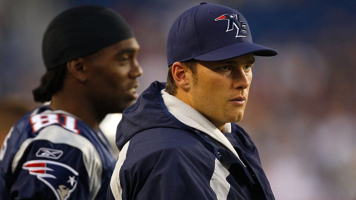 Randy Moss (81) and Tom Brady of the New England Patriots watch the game from the sidelines against the Baltimore Ravens during a preseason game at Gillette Stadium Aug. 7, 2008 in Foxboro, Mass.