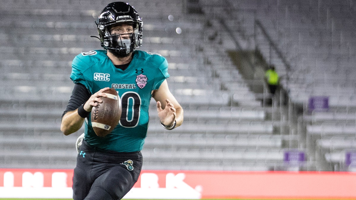 Coastal Carolina quarterback Grayson McCall (10) steps out of the grasp of a Northern Illinois defender during the Cure Bowl NCAA college football game in Orlando, Fla., Friday, Dec. 17, 2021.