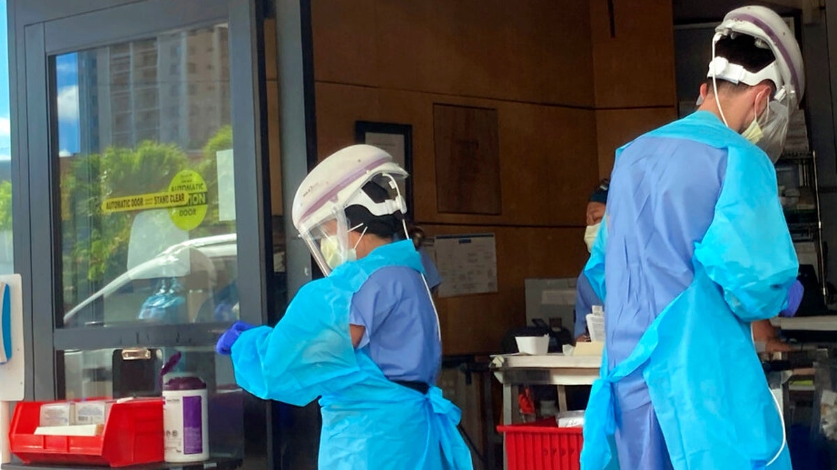 Hospital workers process COVID-19 tests at a hospital in Aiea, Hawaii, Wednesday, Sept. 15, 2021. (AP Photo/Caleb Jones)