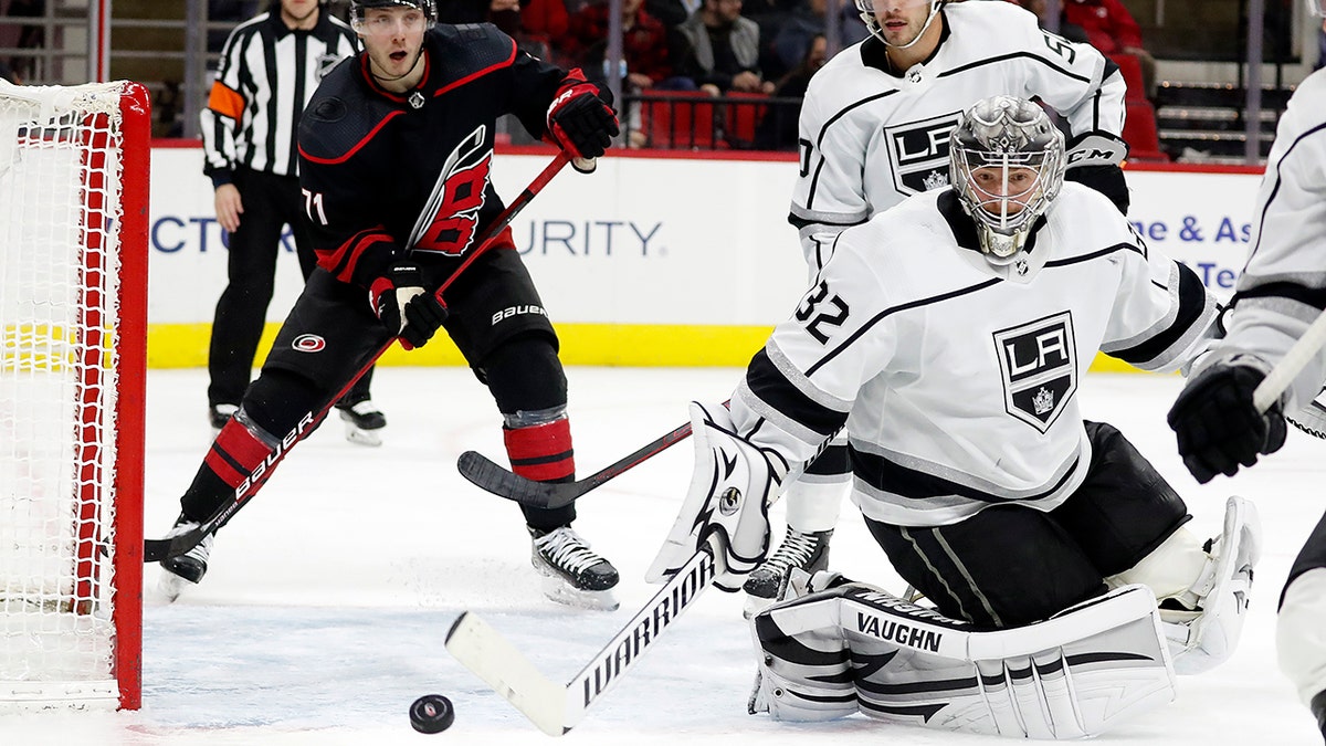 Los Angeles Kings goaltender Jonathan Quick (32) deflects a shot with Carolina Hurricanes' Jesper Fast (71) and teammate Sean Durzi (50) looking on during the second period of an NHL hockey game in Raleigh, N.C., Saturday, Dec. 18, 2021.