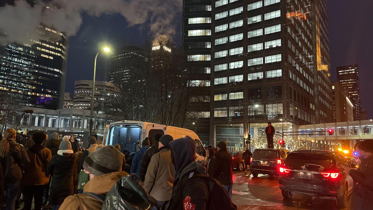 A person stands on a car near the Hennepin County Courthouse in Minneapolis Wednesday during a protest demanding "Justice for Daunte Wright."