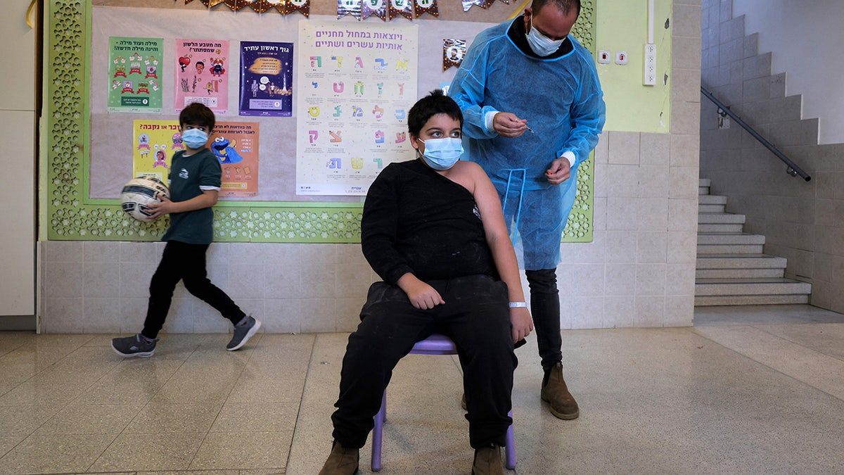 Yinon Weinstock, 9, receives a children's dose of the Pfizer-BioNTech COVID-19 coronavirus vaccine at the Hadasim Elementary school in the Israeli town of Tzur Hadassah , southwest of Jerusalem. 