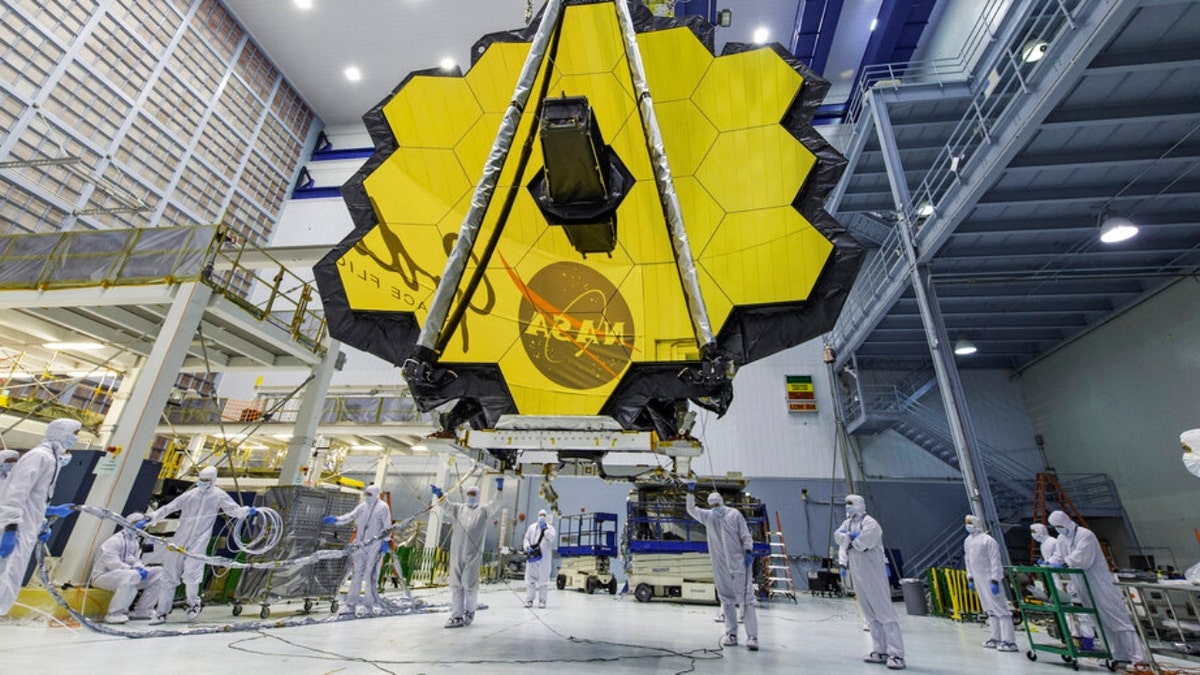 Technicians lift the mirror of the James Webb Space Telescope