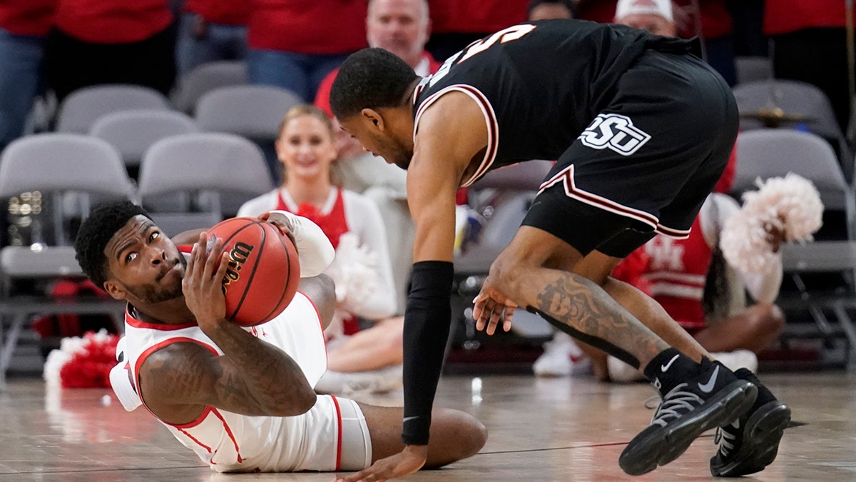 Houston guard Jamal Shead prepares to make a pass in front of Oklahoma State's Rondel Walker, right, after grabbing a loose ball on the court in the second half of an NCAA college basketball game in Fort Worth, Texas, Saturday, Dec. 18, 2021.