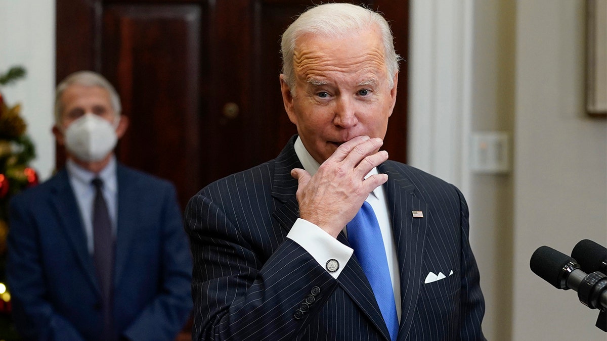 President Biden speaks about the COVID-19 variant named omicron, in the Roosevelt Room of the White House, Monday, Nov. 29, 2021, in Washington. as Dr. Anthony Fauci, director of the National Institute of Allergy and Infectious Diseases listens.