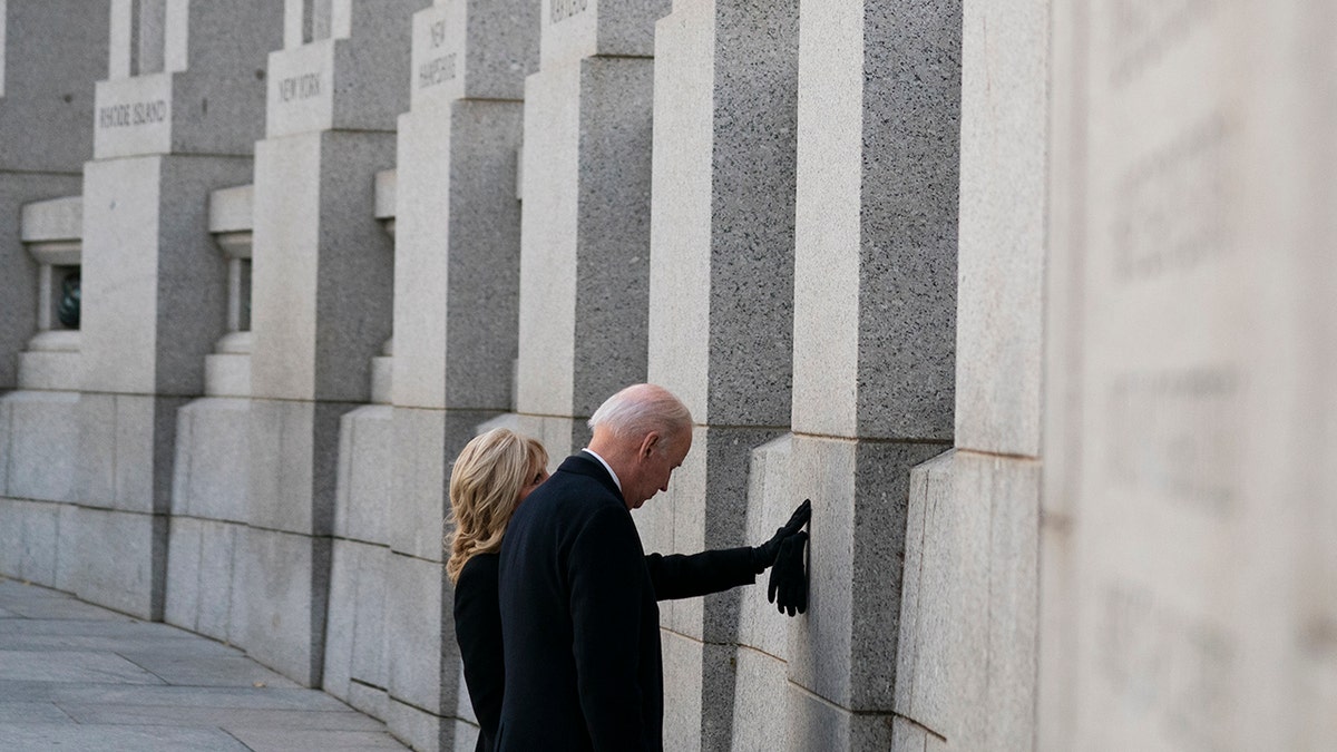 President Biden and first lady Jill Biden visit the National World War II Memorial to mark the 80th anniversary of the Japanese attack on Pearl Harbor, Tuesday, Dec. 7, 2021, in Washington. 
