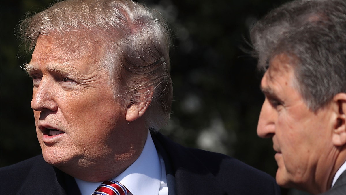President Trump talks with Sen. Joe Manchin, D-W.Va., during an event to honor the 2017 NCAA Football National Champion Alabama Crimson Tide at the White House, on April 10, 2018, in Washington. 