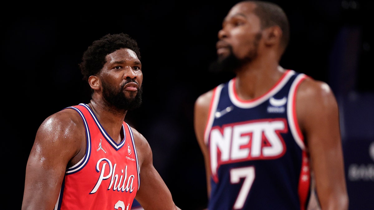Philadelphia 76ers center Joel Embiid (21) looks toward Brooklyn Nets forward Kevin Durant (7) during the second half of an NBA basketball game Thursday, Dec. 30, 2021, in New York. 