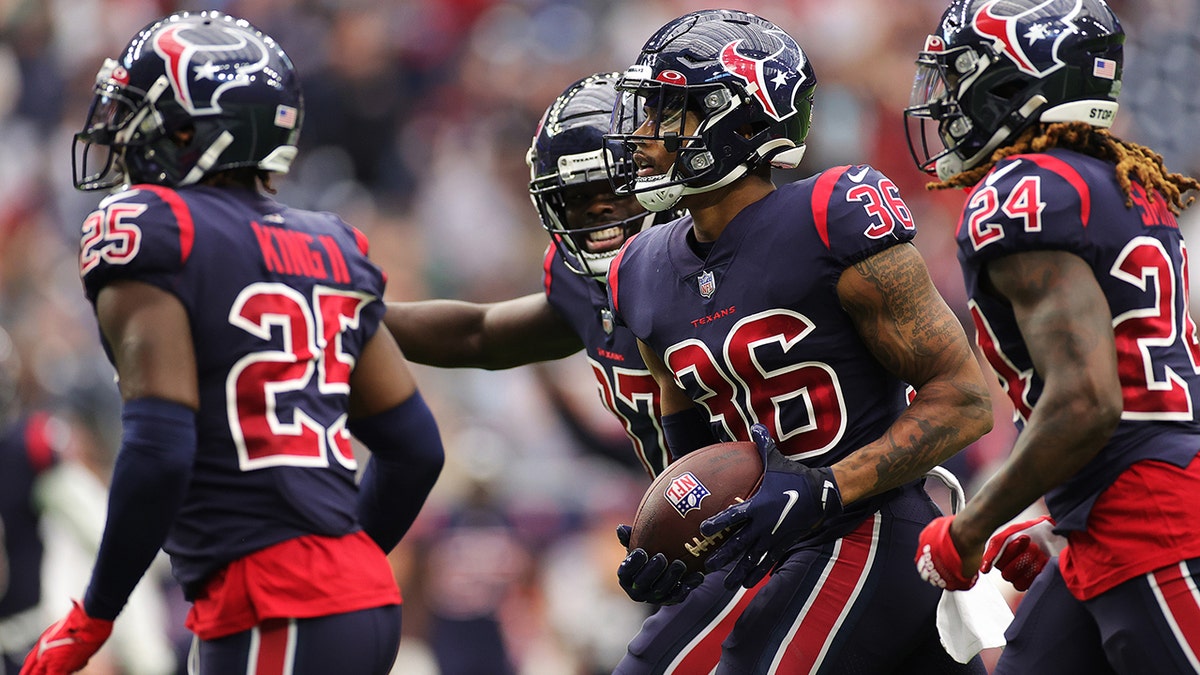 Jonathan Owens #36 of the Houston Texans celebrates his interception with teammates during the second quarter against the Los Angeles Chargers at NRG Stadium on December 26, 2021 in Houston, Texas.