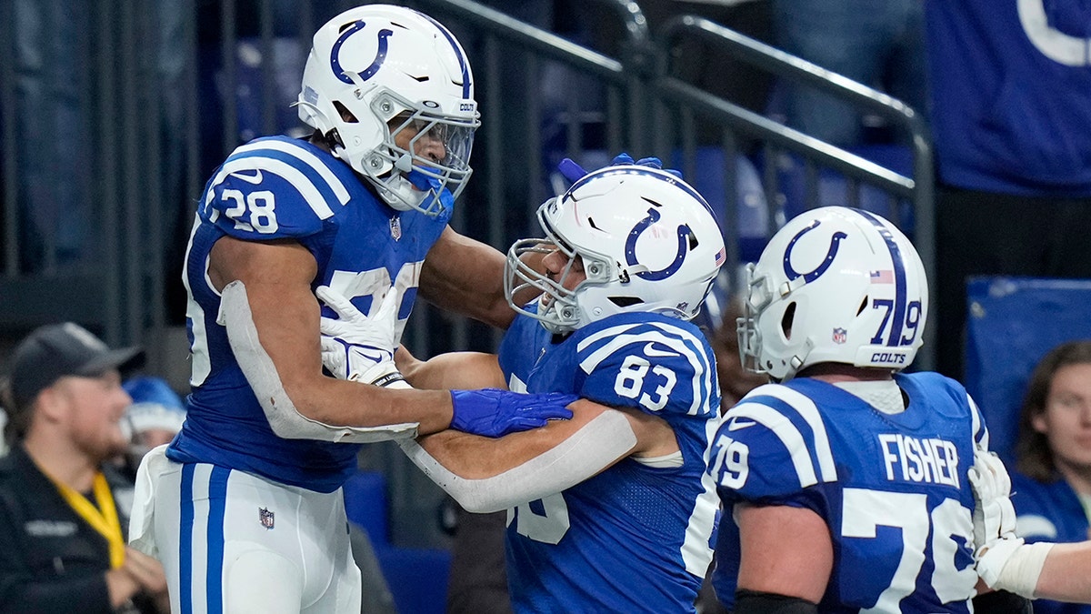 Indianapolis Colts running back Jonathan Taylor (28) is congratulated by Kylen Granson (83) and Eric Fisher (79) after scoring on a 67-yard touchdown run during the second half of an NFL football game against the New England Patriots Saturday, Dec. 18, 2021, in Indianapolis.