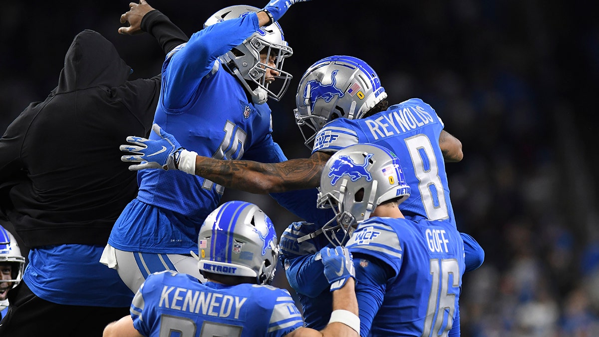 Teammates congratulate Detroit Lions wide receiver Josh Reynolds (8) after his touchdown during the first half of an NFL football game against the Arizona Cardinals, Sunday, Dec. 19, 2021, in Detroit.