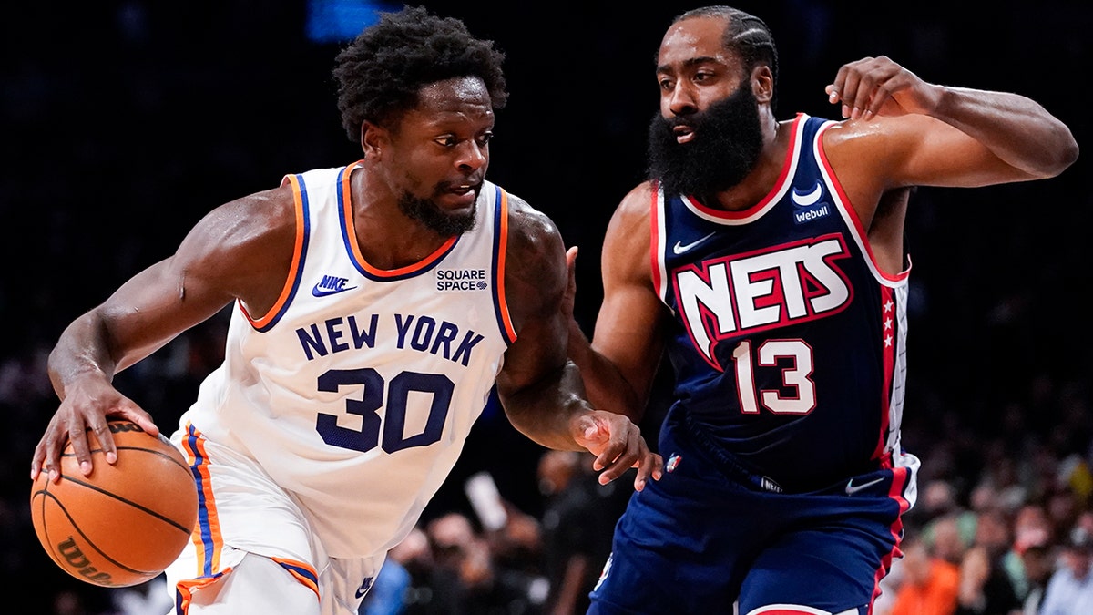 New York Knicks forward Julius Randle (30) drives against Brooklyn Nets guard James Harden (13) during Tuesday, Nov. 30, 2021, in New York. 