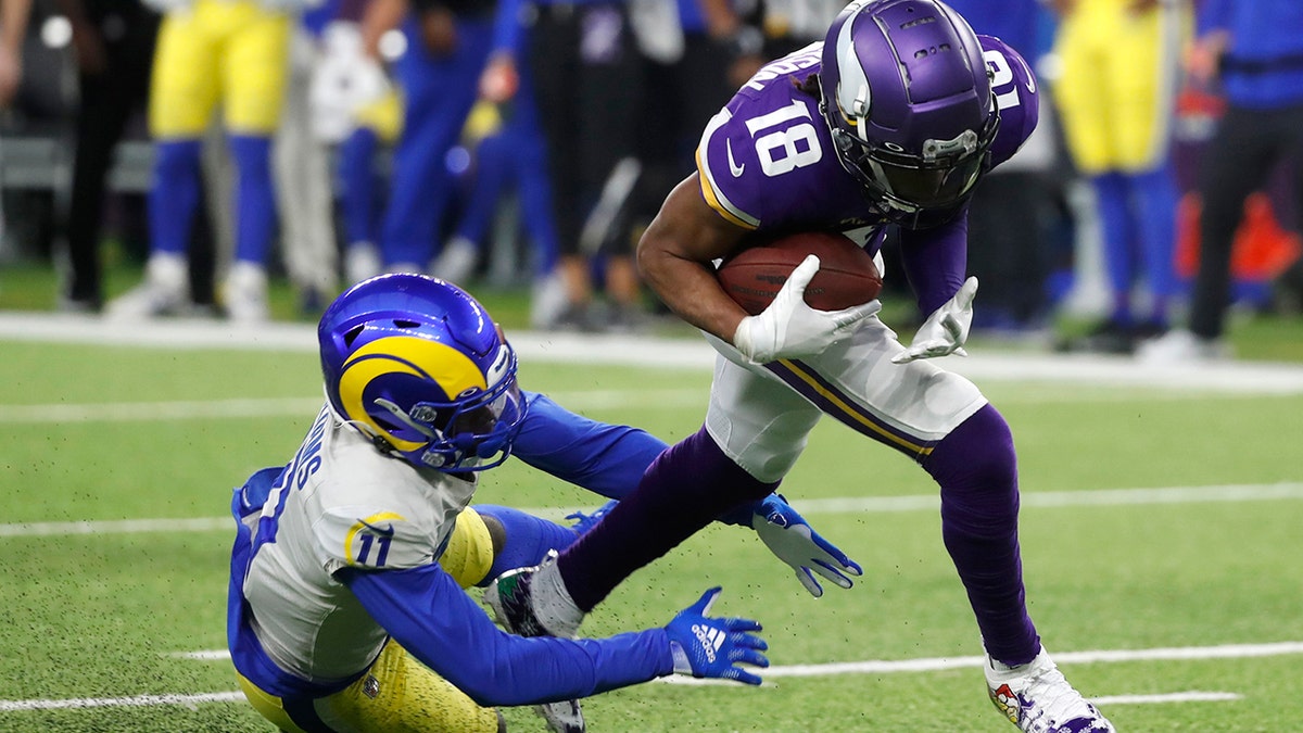 Minnesota Vikings wide receiver Justin Jefferson (18) runs from Los Angeles Rams cornerback Darious Williams (11) after catching a pass during the second half of an NFL football game, Sunday, Dec. 26, 2021, in Minneapolis.