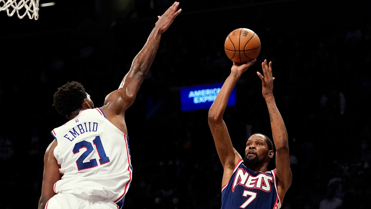 Brooklyn Nets forward Kevin Durant (7) shoots a basket over Philadelphia 76ers center Joel Embiid (21) during the second half of an NBA basketball game, Thursday, Dec. 16, 2021, in New York. The Nets won 114-105.