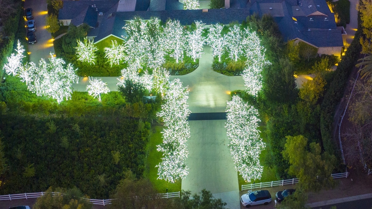 Kim Kardashian's tree-lined drive lit up with bright white lights.