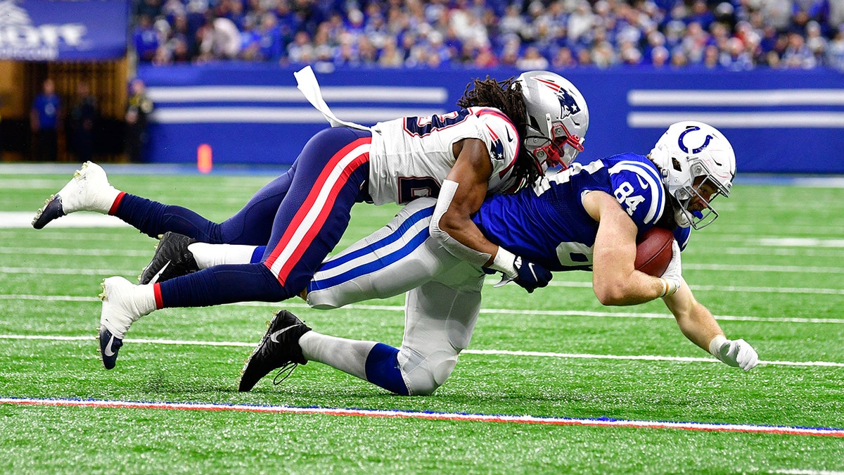 New England Patriots safety Kyle Dugger (23) tackles Indianapolis Colts tight end Jack Doyle (84) during the second half at Lucas Oil Stadium. The Colts won 27-17. 