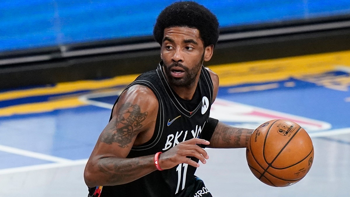 Brooklyn Nets' Kyrie Irving moves the ball during the first half of an NBA basketball game against the Cleveland Cavaliers Sunday, May 16, 2021, in New York.