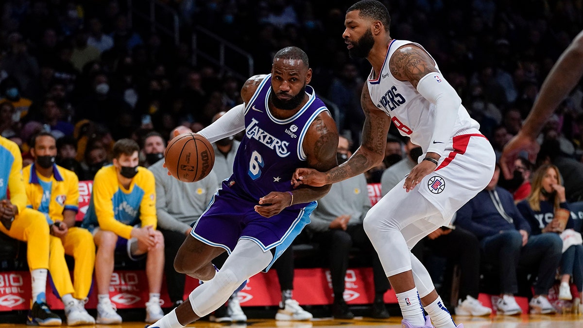 Los Angeles Clippers forward Marcus Morris Sr. (8) defends against Los Angeles Lakers forward LeBron James (6) during the second half of an NBA basketball game in Los Angeles, Friday, Dec. 3, 2021.