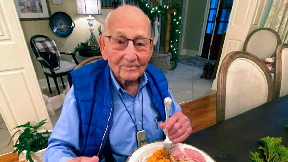 World War II veteran Major Wooten enjoys his Thanksgiving dinner with family in Madison, Alabama, on Nov. 25, 2021. (Holly McDonald via AP)