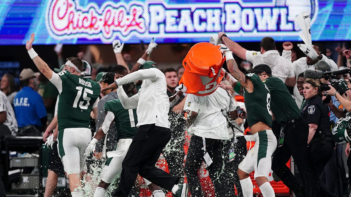 The Michigan State team celebrates a victory over Pittsburgh after the Peach Bowl NCAA college football game, Thursday, Dec. 30, 2021, in Atlanta. Michigan State won 31-21.