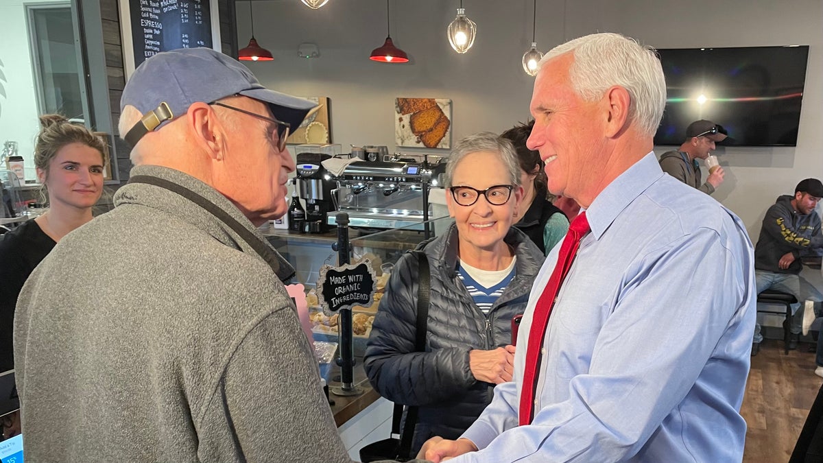 Former Vice President Mike Pence, during a trip to New Hampshire, greets customers at Simply Delicious Bakery in Bedford on Dec. 8, 2021.