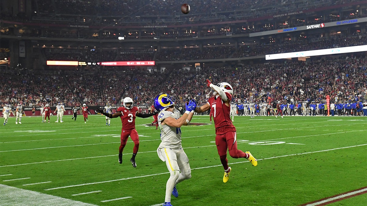 Cooper Kupp #10 of the Los Angeles Rams looks to make a catch while being defended by Byron Murphy Jr #7 of the Arizona Cardinals at State Farm Stadium on Dec. 13, 2021 in Glendale, Arizona. 